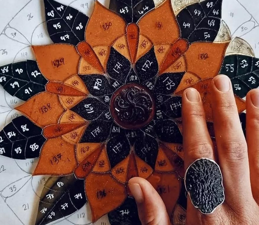 Image of a sunflower mandala stained glass window by artist Yiscah Rosemary featuring 188 pieces of glass which have been numbered but not yet soldered together